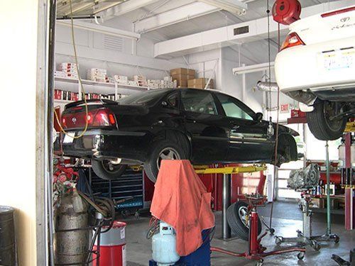 Black car on the lifts at Northeast Transmission Repair Shop