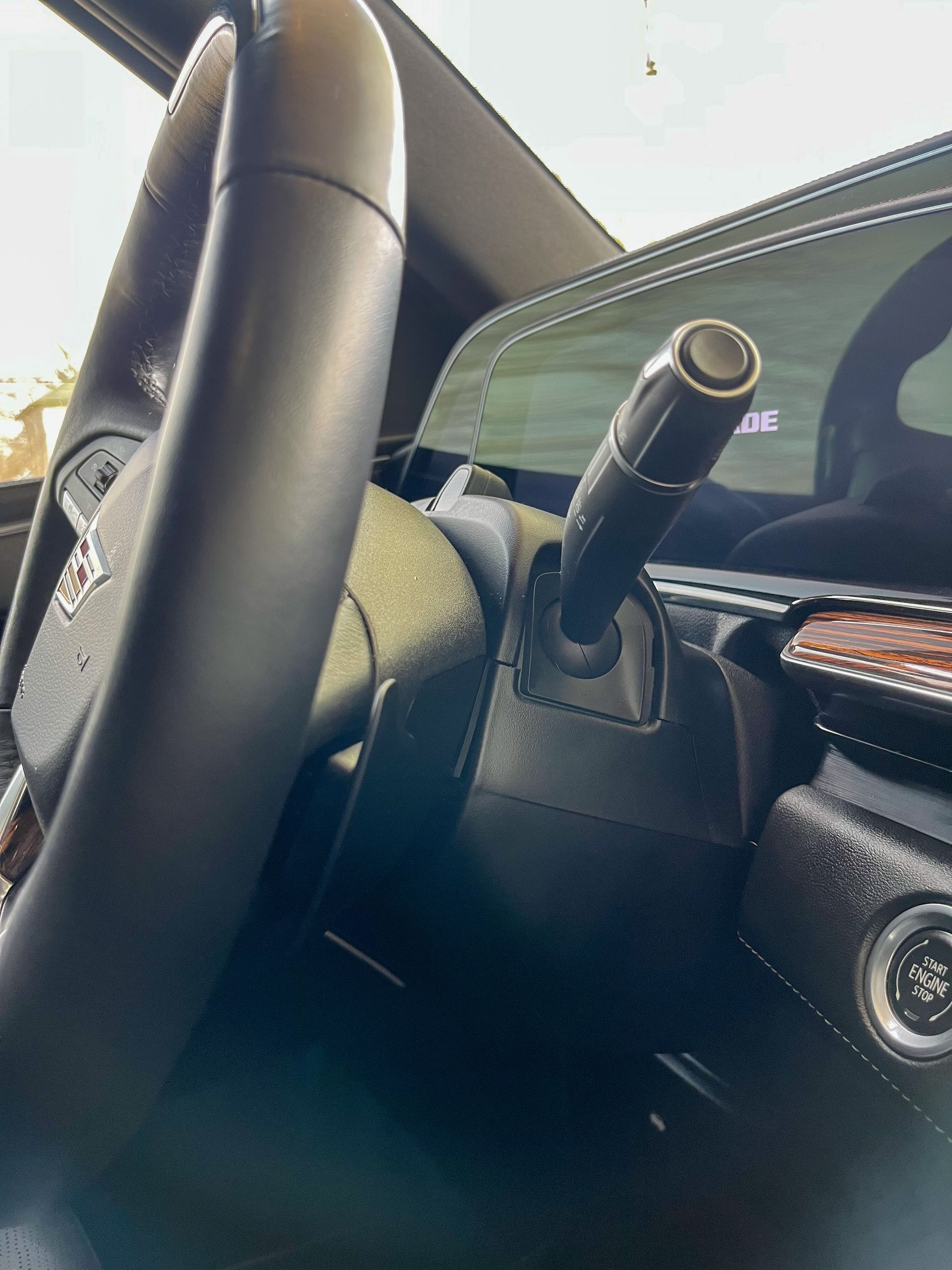 A person wearing black gloves is polishing a black car