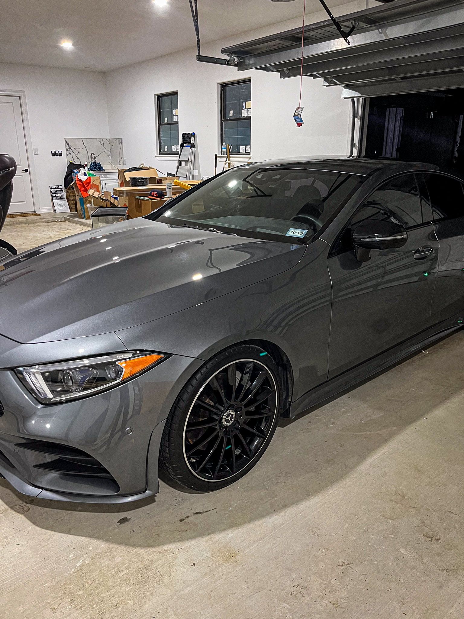 Gray sports coupe parked in a garage with black wheels and a front-left angle view