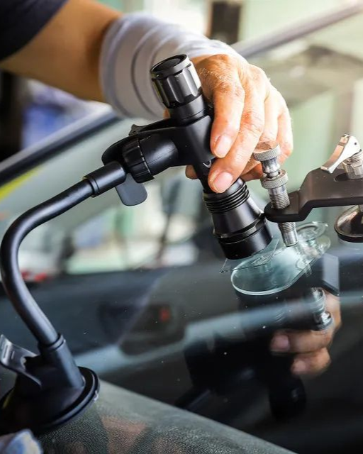 A man is cleaning the wheel of a black car with a sponge.