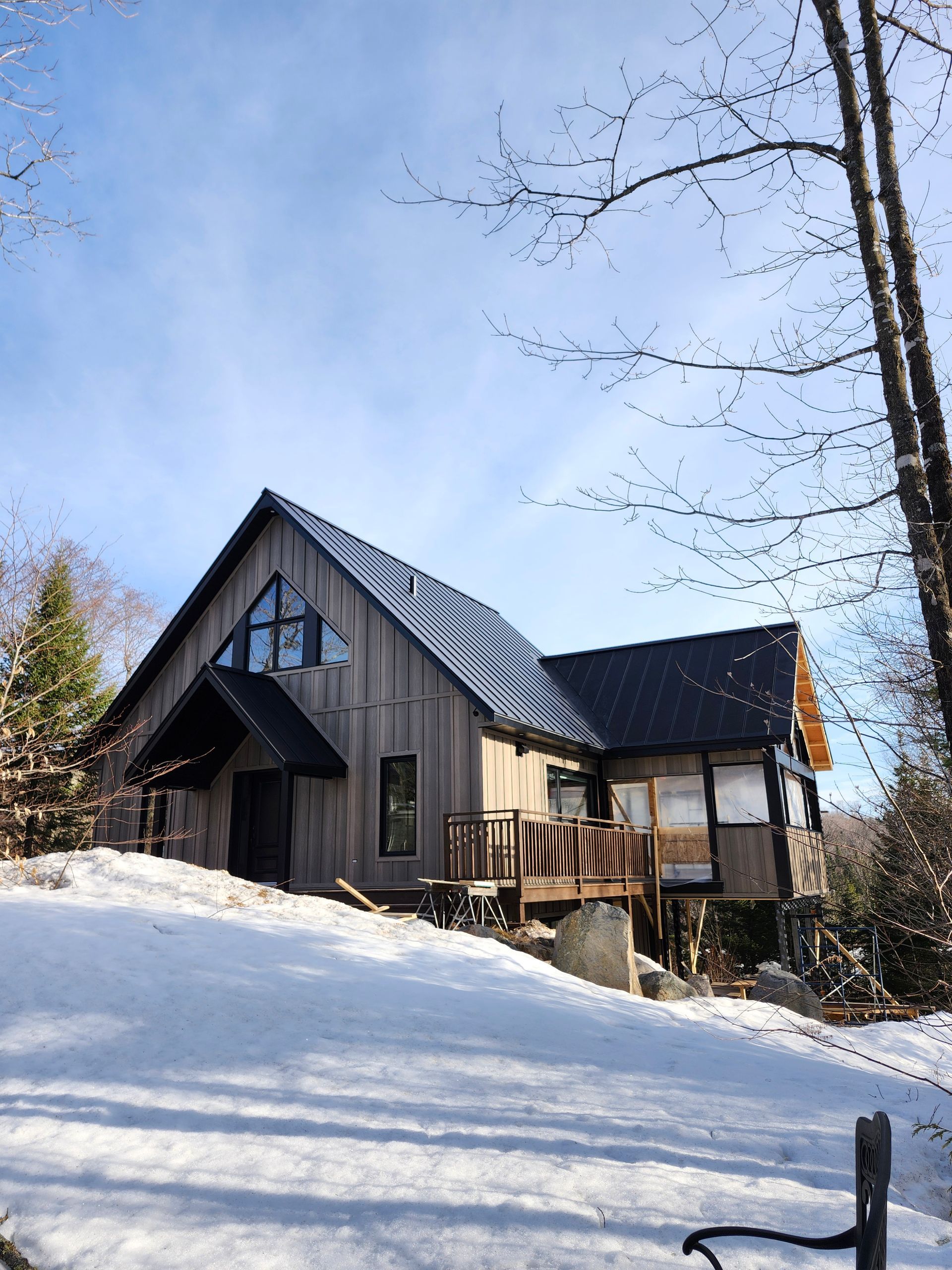 Une grande maison est située au sommet d'une colline couverte de neige.