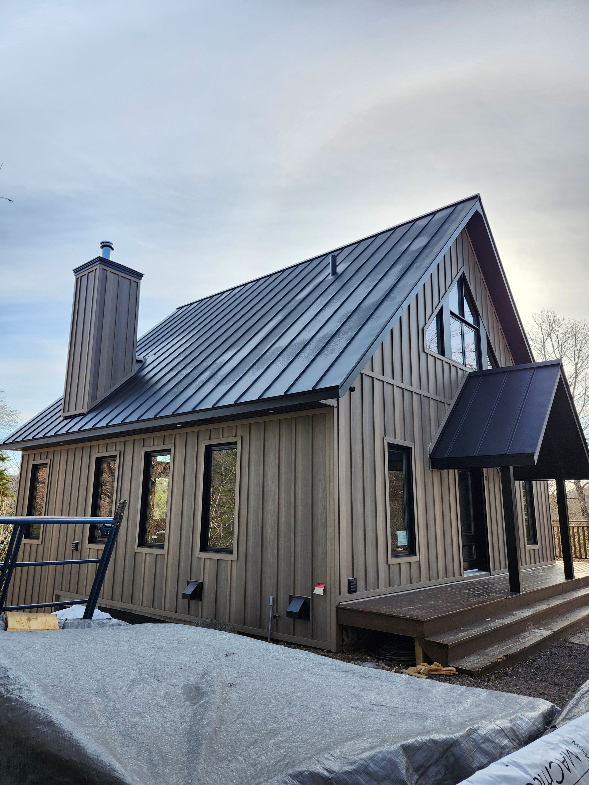 Une maison en bois avec un toit en métal et un porche