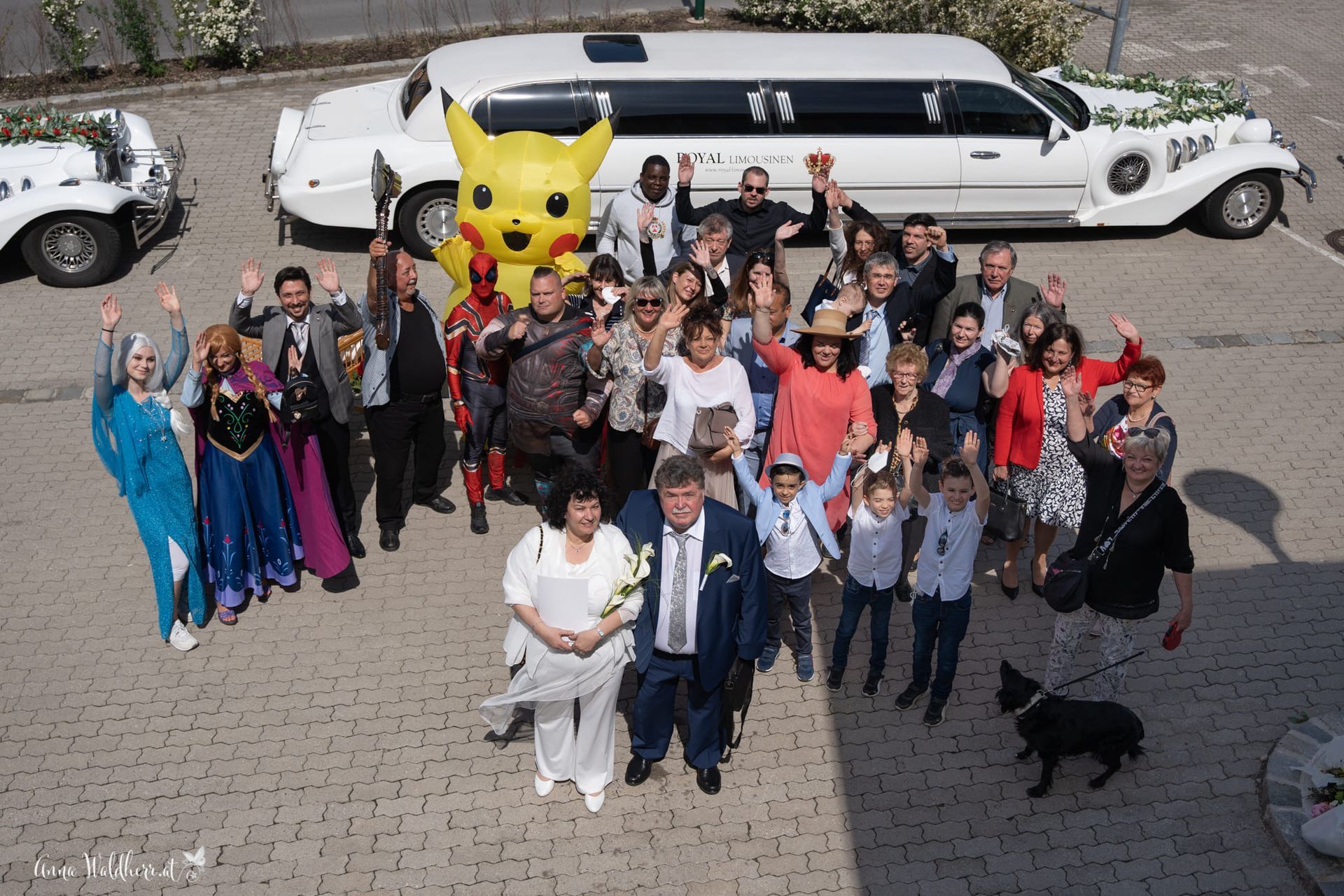 Eine Gruppe von Menschen posiert vor einer Limousine für ein Foto.