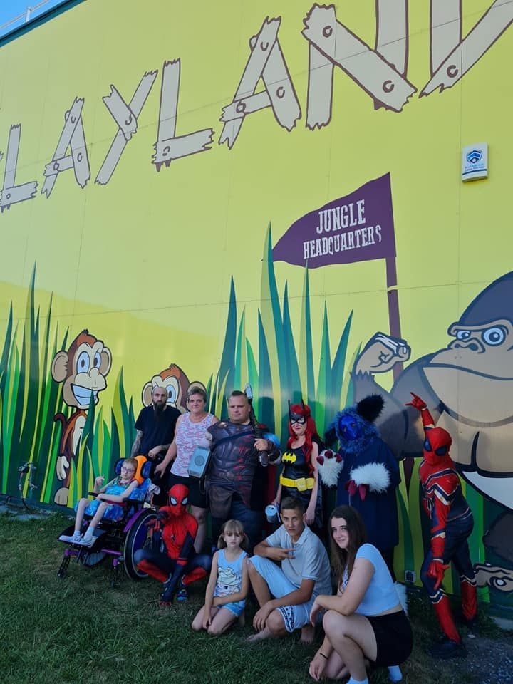 Eine Gruppe von Menschen posiert vor einer gelben Wand für ein Foto.