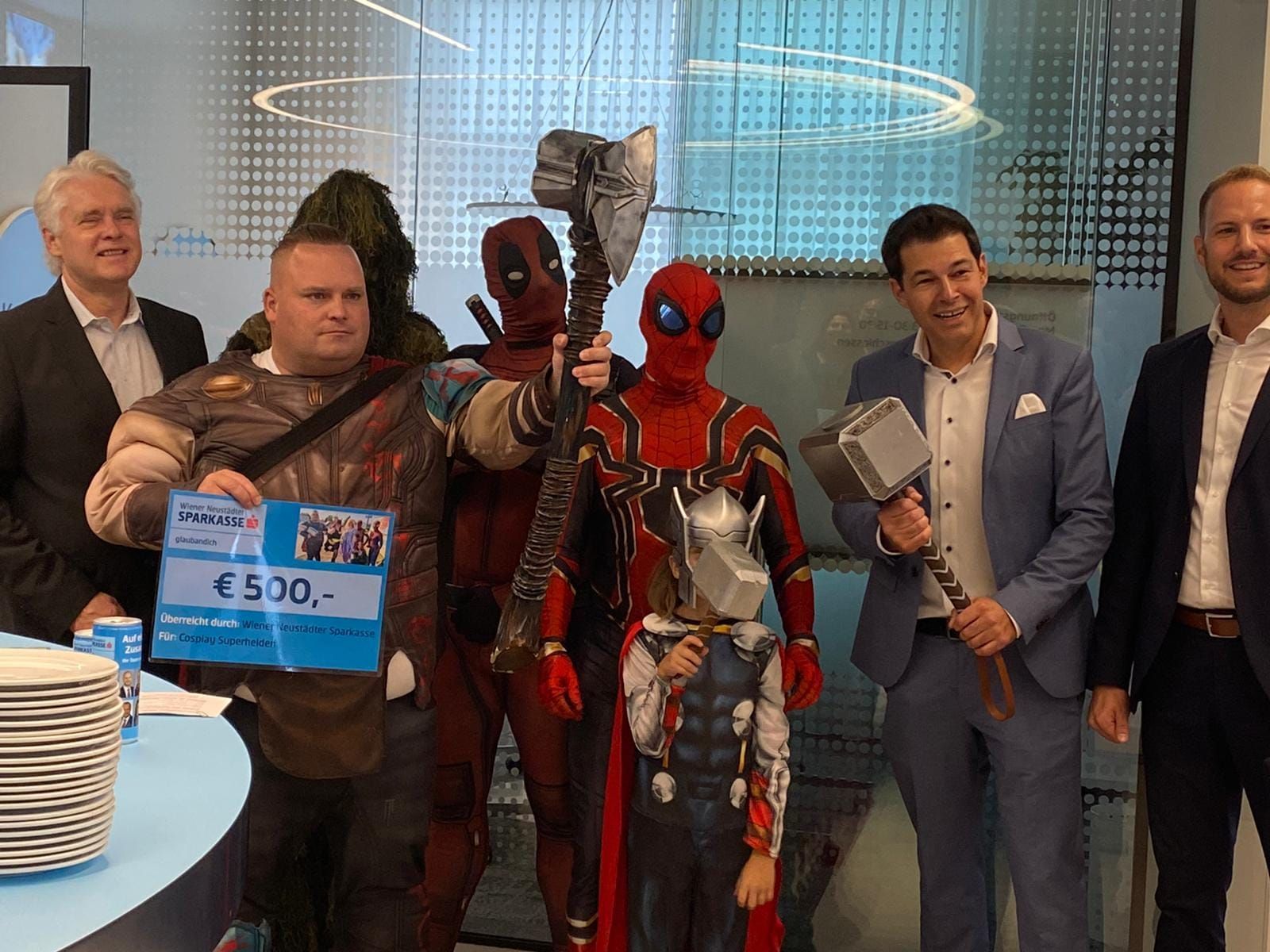 Eine Gruppe von Männern in Superheldenkostümen posiert für ein Foto.