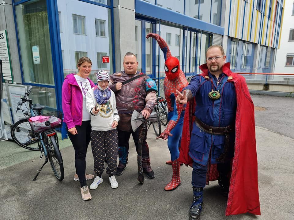 Eine Gruppe von Menschen posiert für ein Foto vor einem Geschäft mit Schützling.