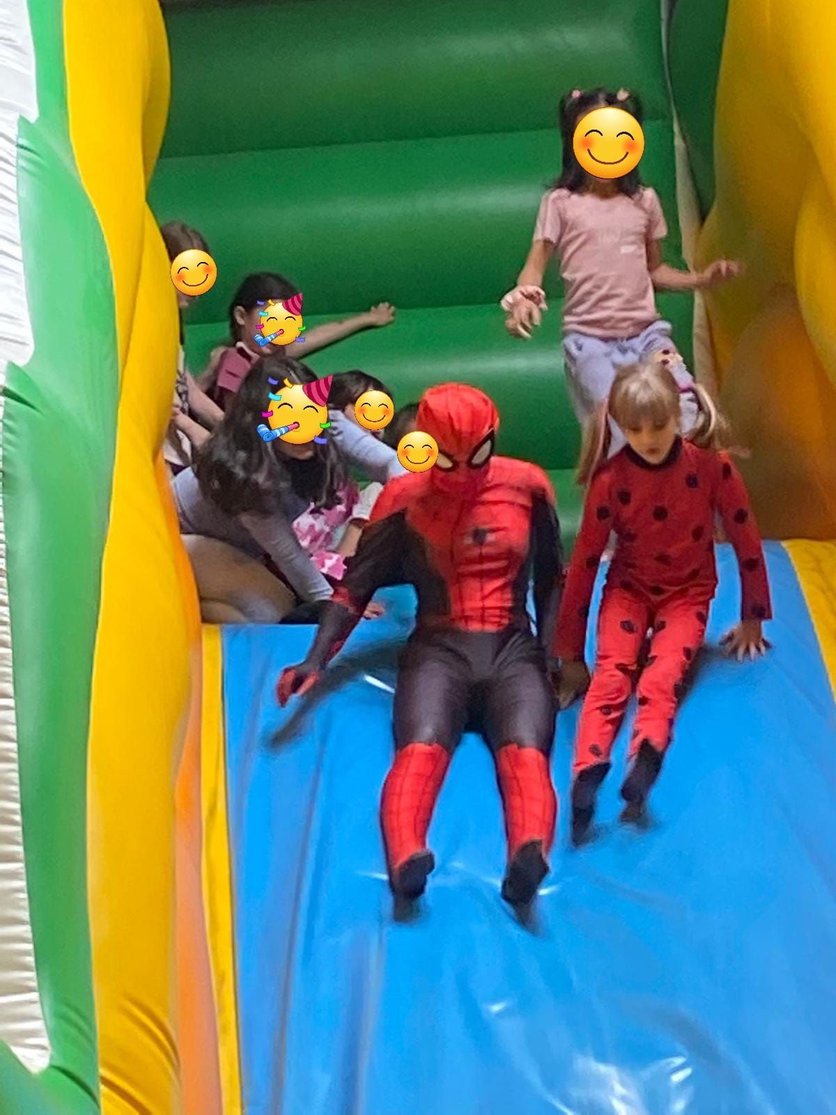 Eine Gruppe Kinder spielt auf einer aufblasbaren Rutsche.