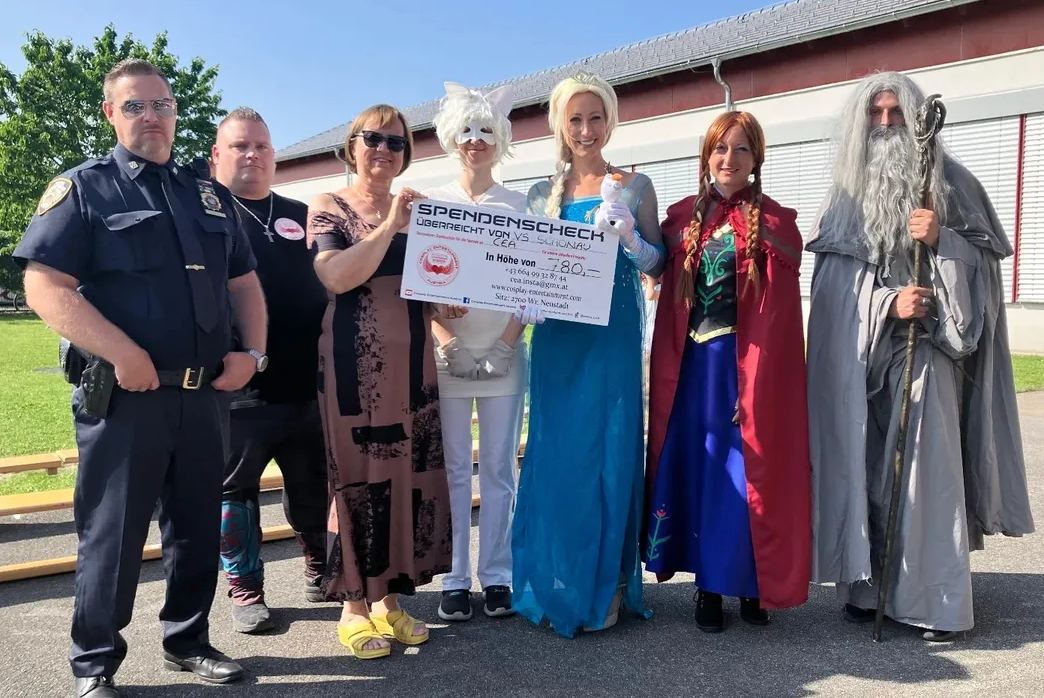 Eine Gruppe von Menschen bei einer Spendenscheckübergabe.