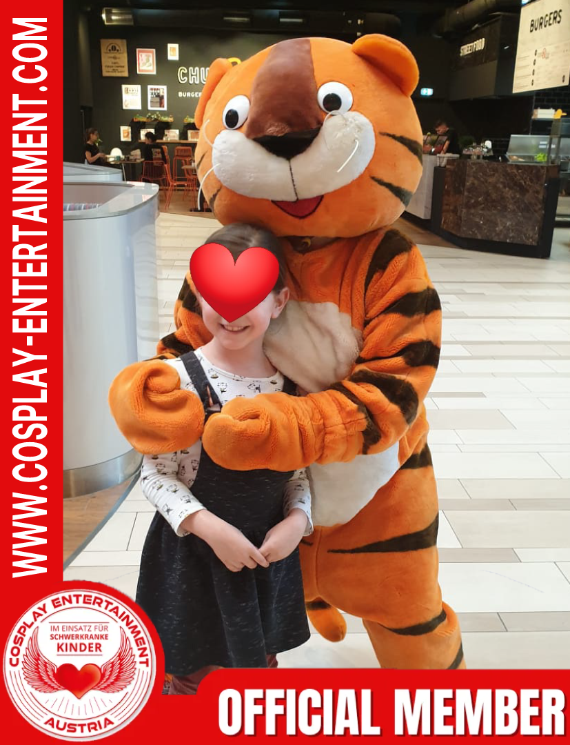 Ein Mädchen umarmt ein Tigermaskottchen, das ein offizielles Mitglied ist