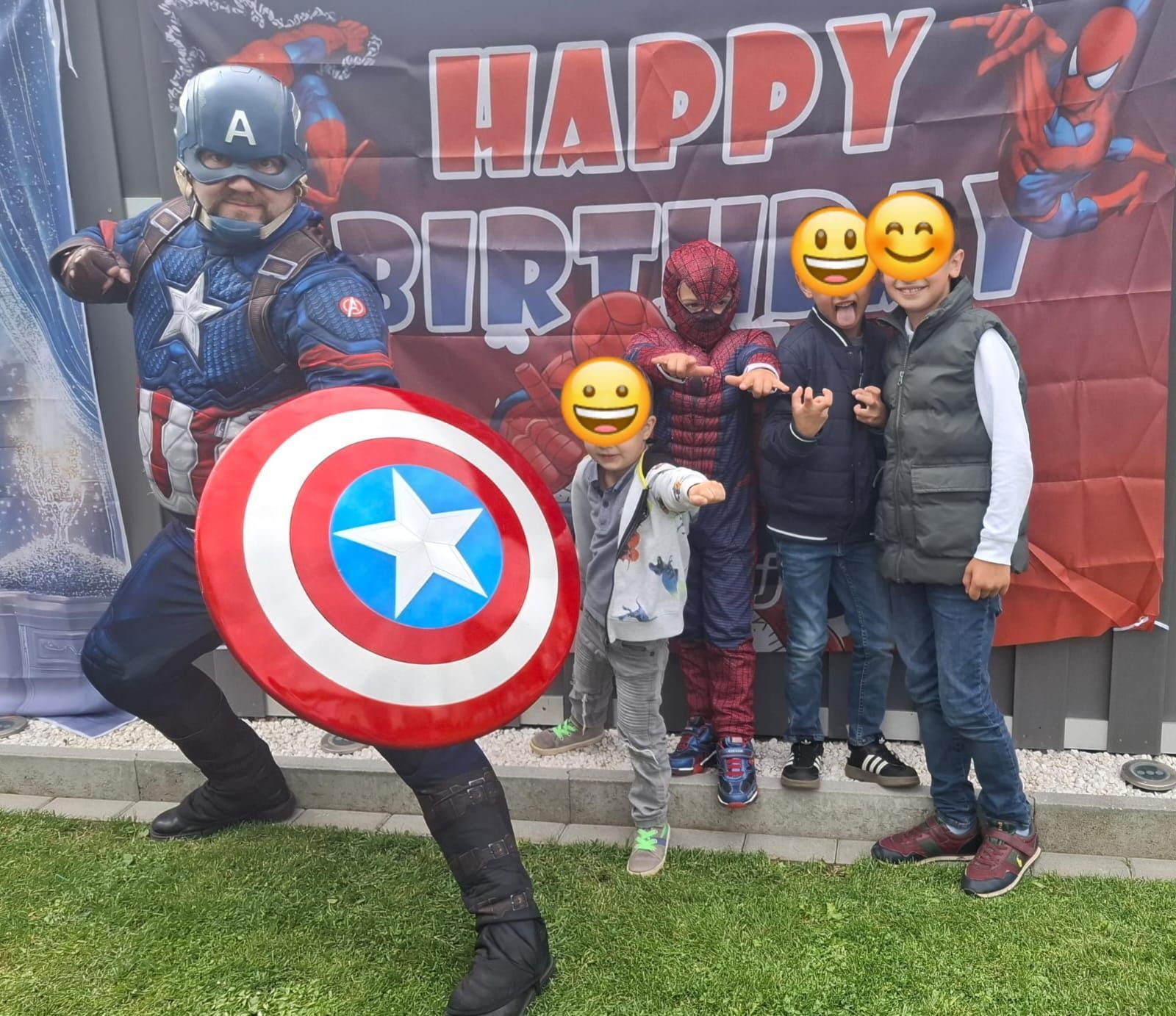 Eine Gruppe Kinder posiert für ein Foto mit einem als Captain America verkleideten Mann.