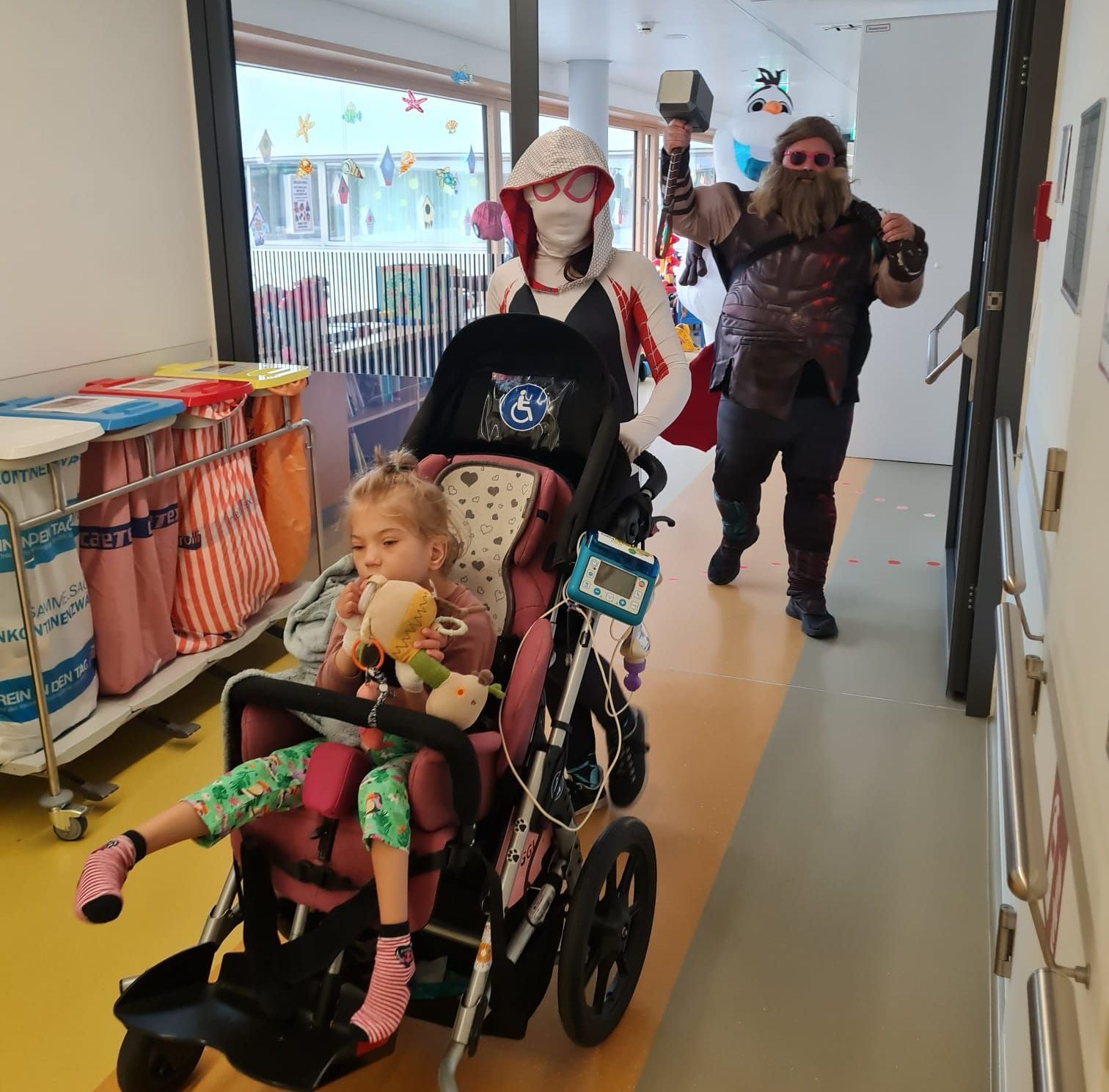 Ein Kind in einem Kinderwagen wird von einer kostümierten Person geschoben.