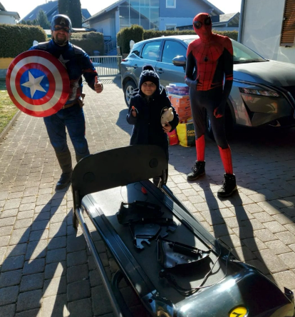 Ein Mann in einem Captain America-Kostüm und einem Spiderman-Kostüm bei der Wunscherfüllung eines Schützlings.