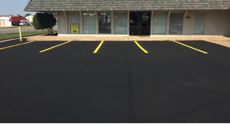 Empty parking lot with fresh yellow lines in front of a row of storefronts