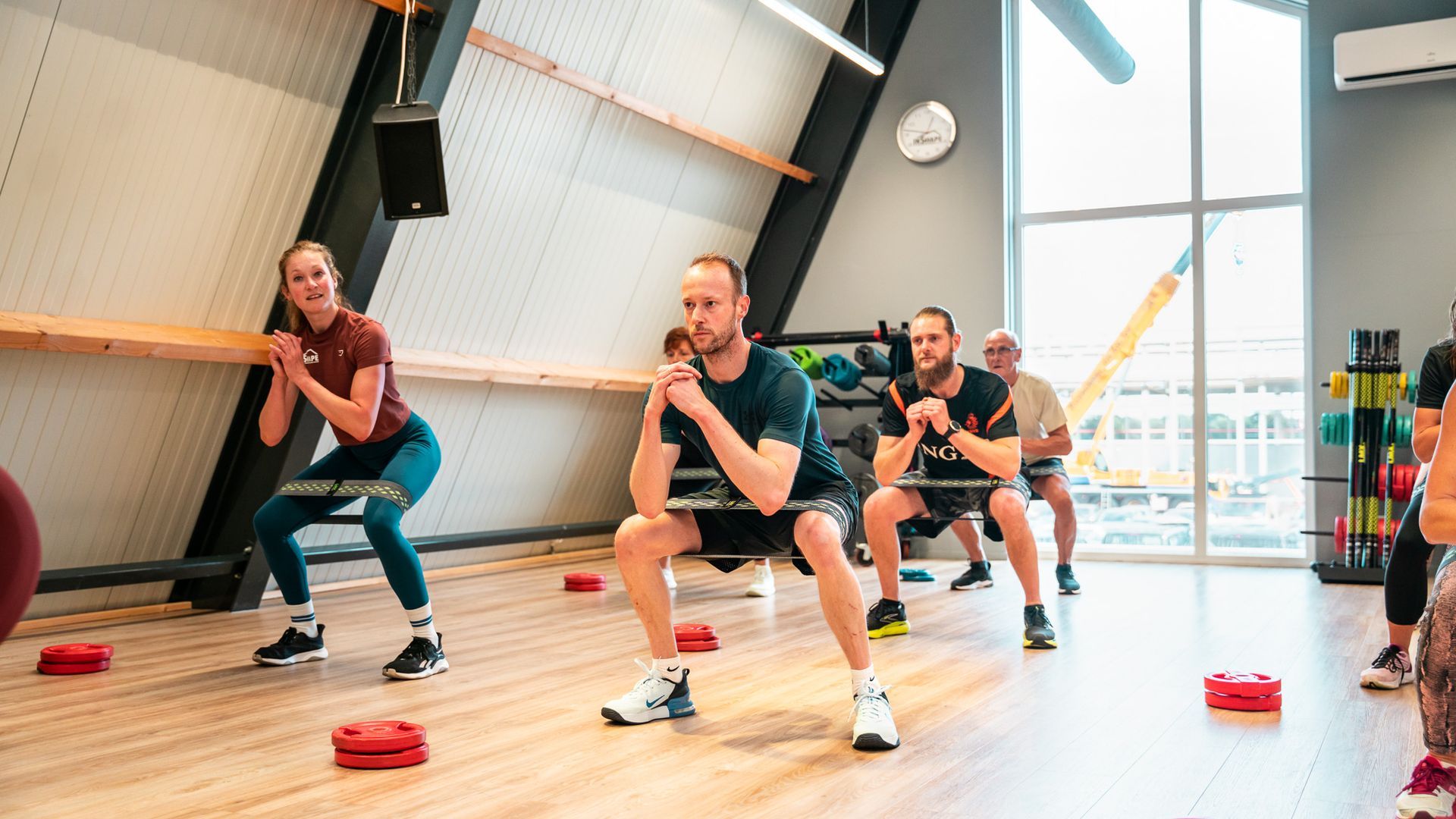Een groep mensen doet oefeningen in een sportschool.