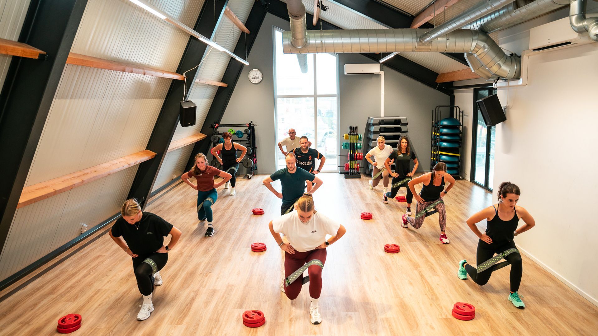 Een groep mensen tilt halters op in een sportschool.