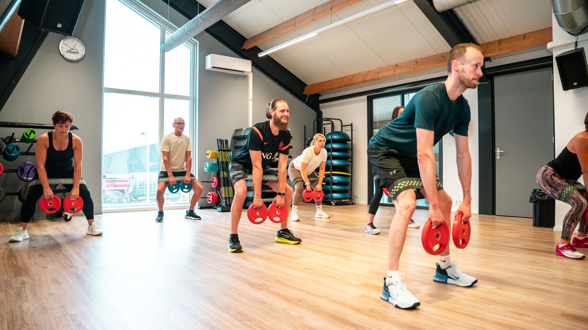 Een vrouw squat met een halter in een sportschool.