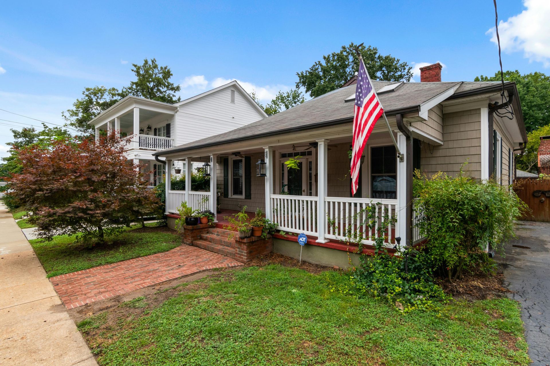 Single-family suburban home with an American flag on the porch.