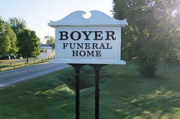 a white sign that says boyer funeral home on it