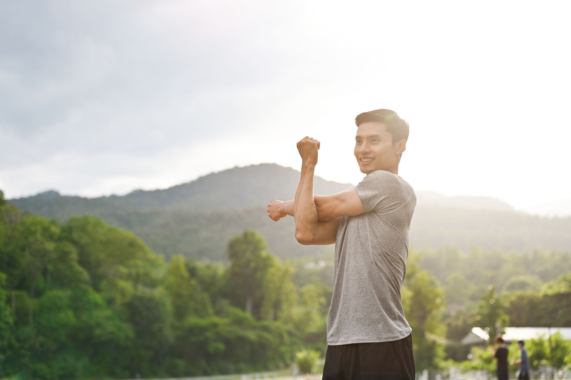 A middle-aged person exercises and looks fresh in morning light.