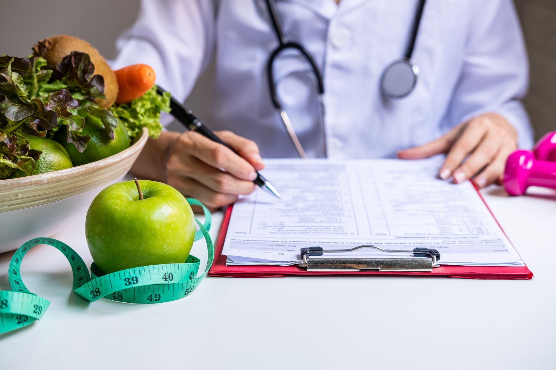 A nutritionist creates a diet plan and nutrition chart while sitting at a desk.