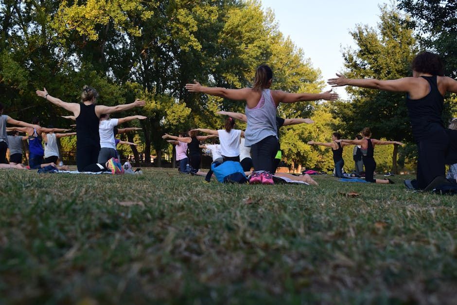 A group of people are doing yoga in a park.