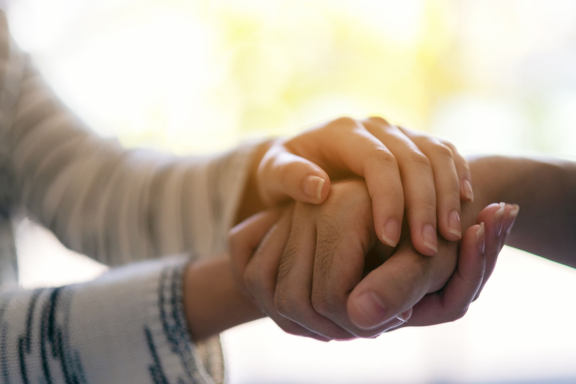 A close up of a person holding another person's hand.