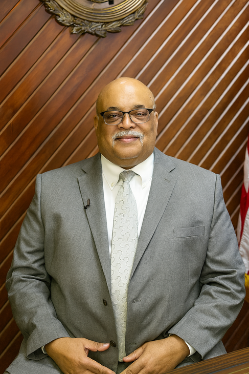 Houston personal injury attorney in a suit and tie standing in front of a piano