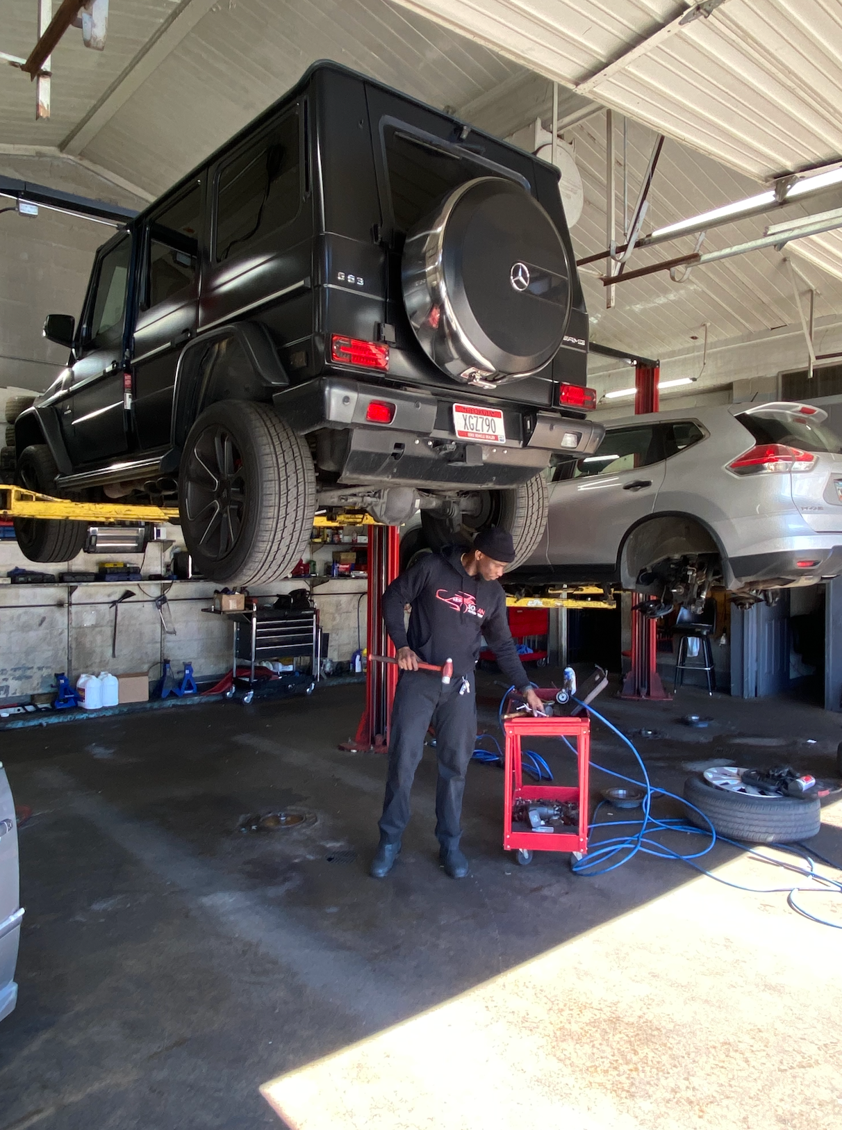A man is working on a car in a garage.