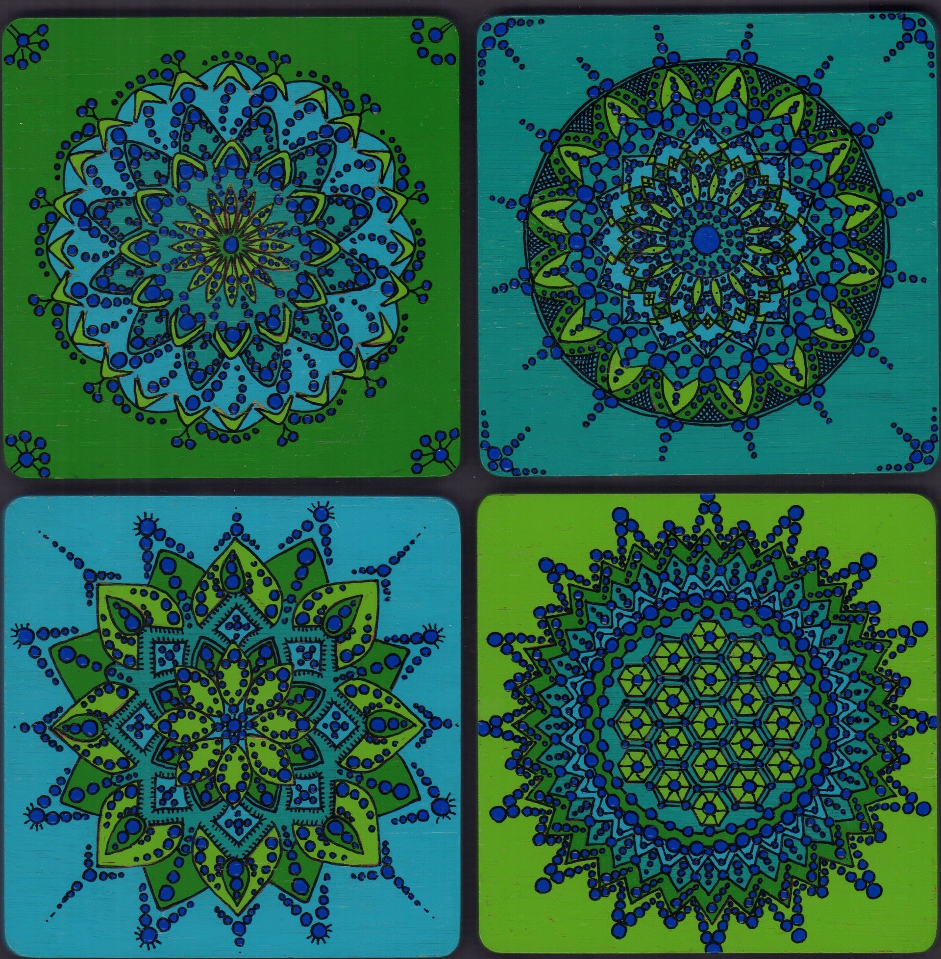 Vier vierkante onderzetters met mandala-ontwerpen in blauwe en groene tinten.