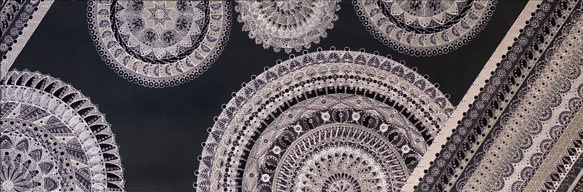 Zwarte achtergrond met gedetailleerde witte cirkelvormige en hoekige patronen.