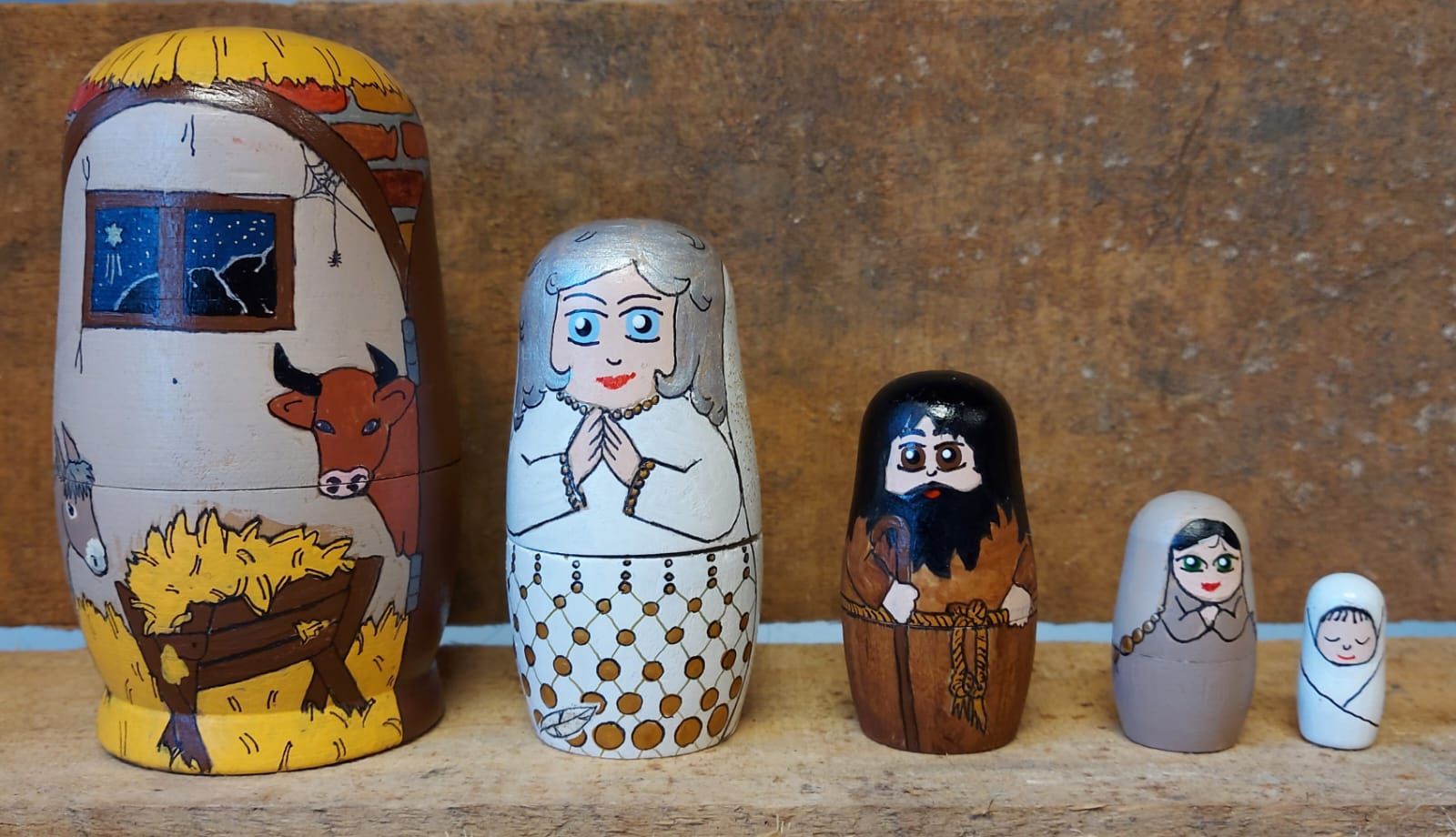 Russische matroesjka-poppen die de kerststal uitbeelden: de stal, Maria, Jozef en het kindje Jezus.