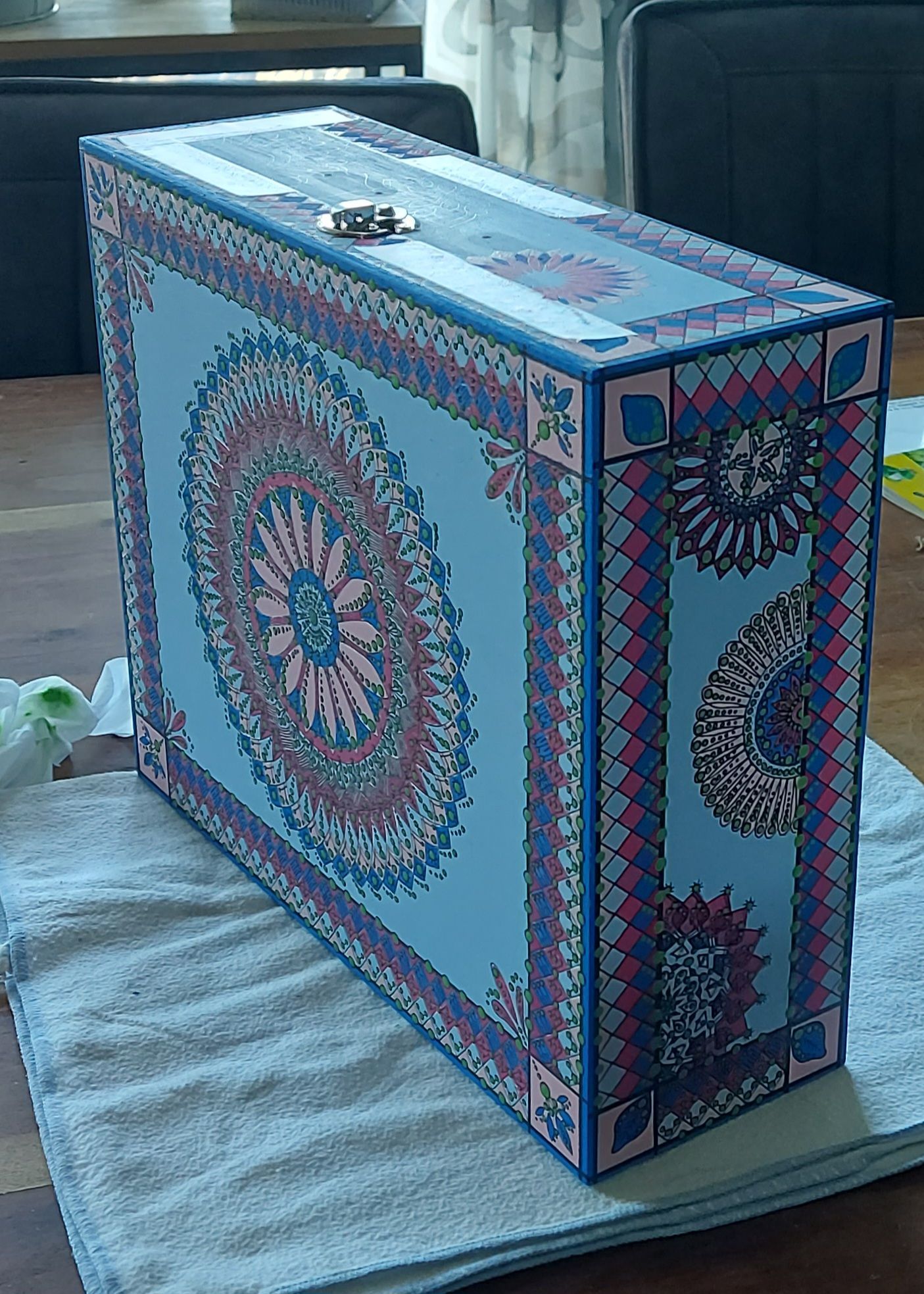 Decoratieve blauwe doos met een ingewikkeld mandala-achtig ontwerp voorzien van een metalen sluiting.