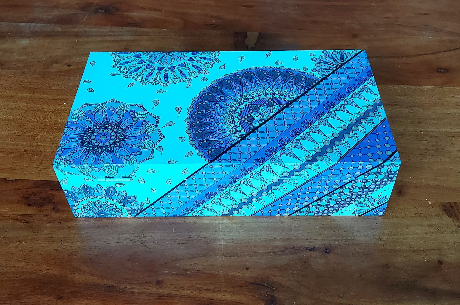 Een doos met blauw patroon op een houten ondergrond.