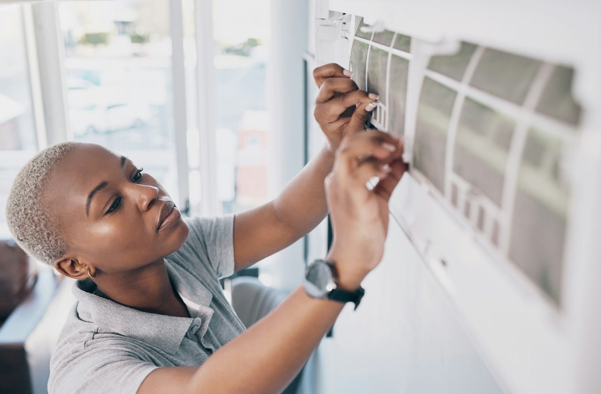 Chilled Haven Cooling & Heating technician, a black woman, repairing an air conditioning unit and electrical system for maintenance in Phoenix, Arizona