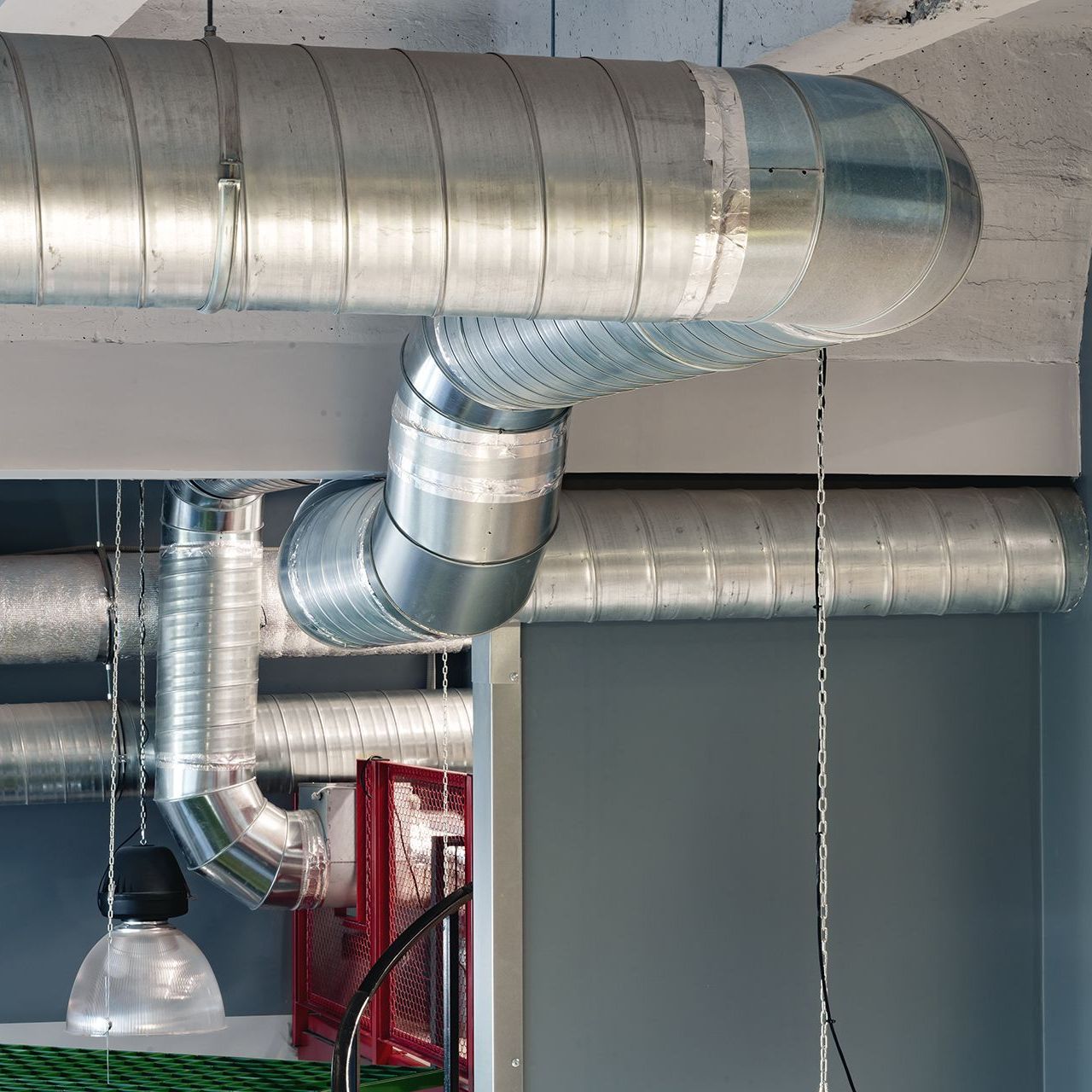 A room with a lot of metal pipes hanging from the ceiling