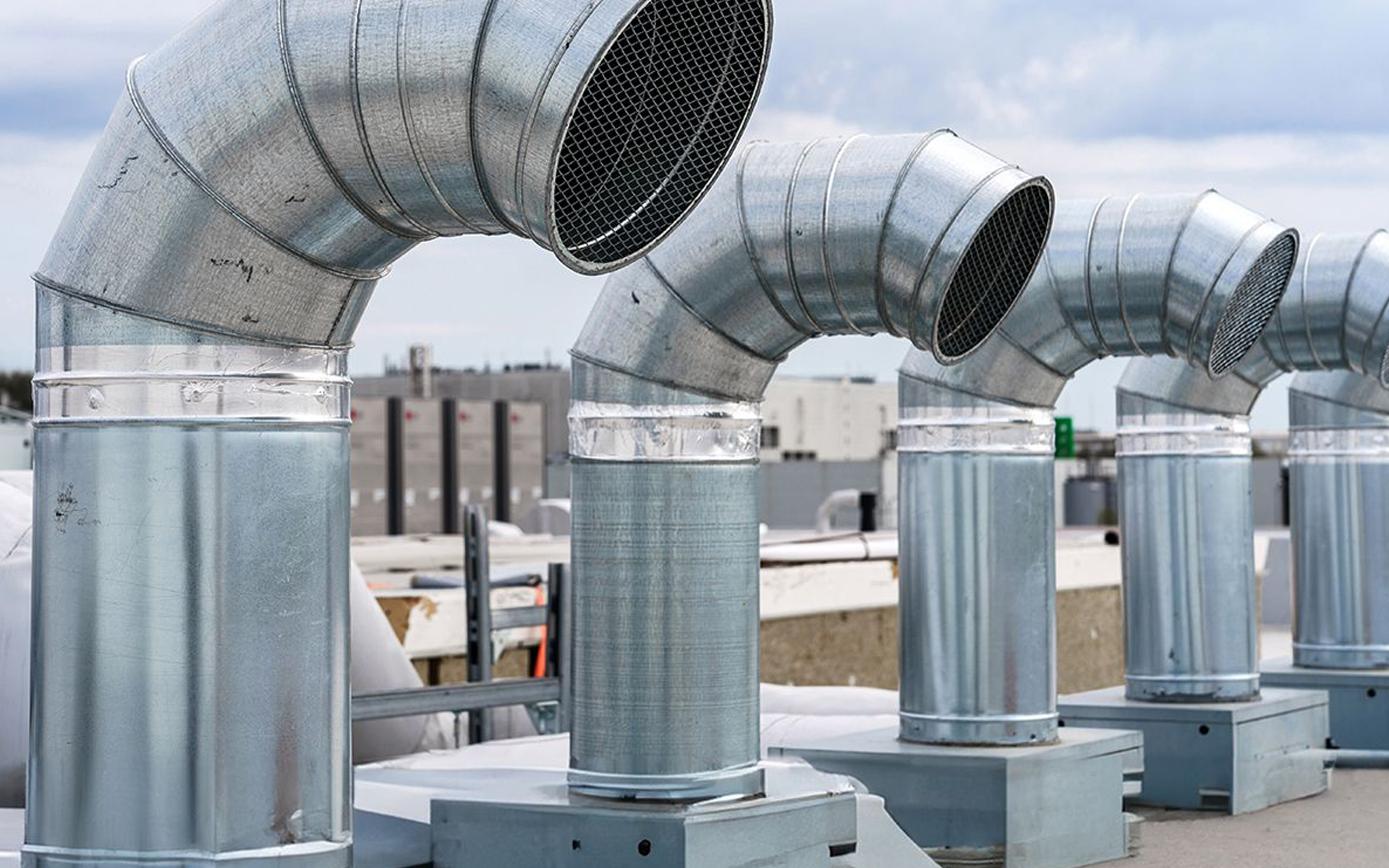 A row of metal pipes on top of a building.