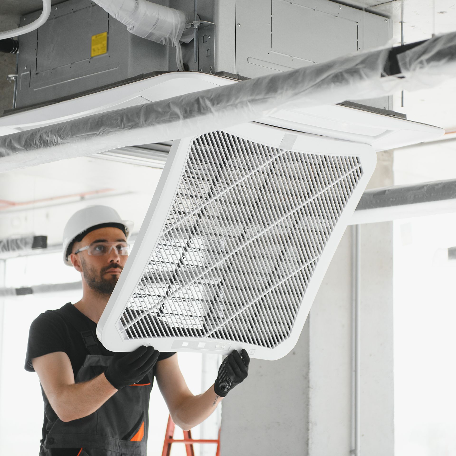 A man is holding a filter that is hanging from the ceiling.