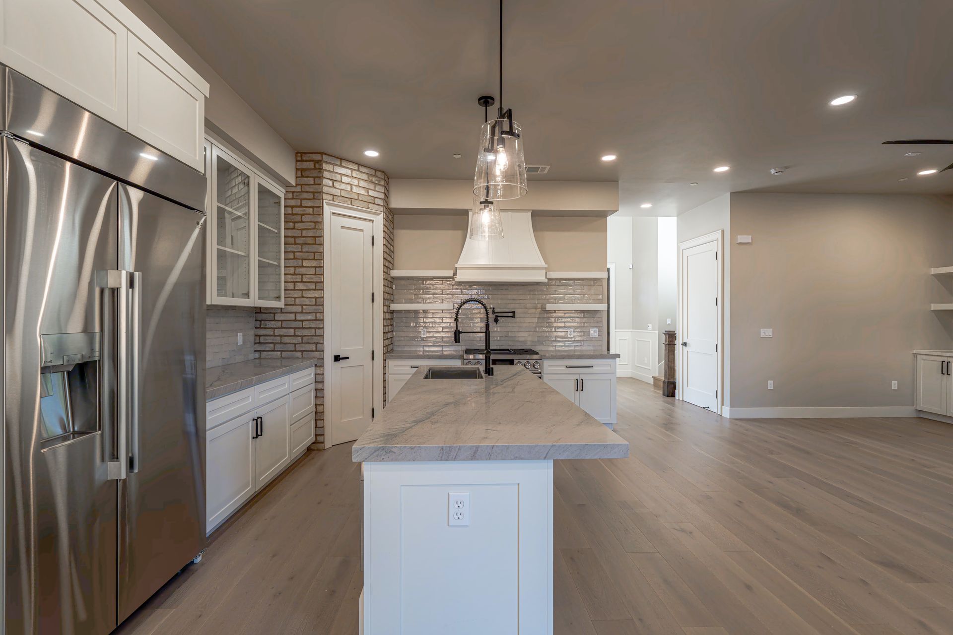 Modern kitchen with stainless steel appliances, white cabinets, and a gray countertop island.