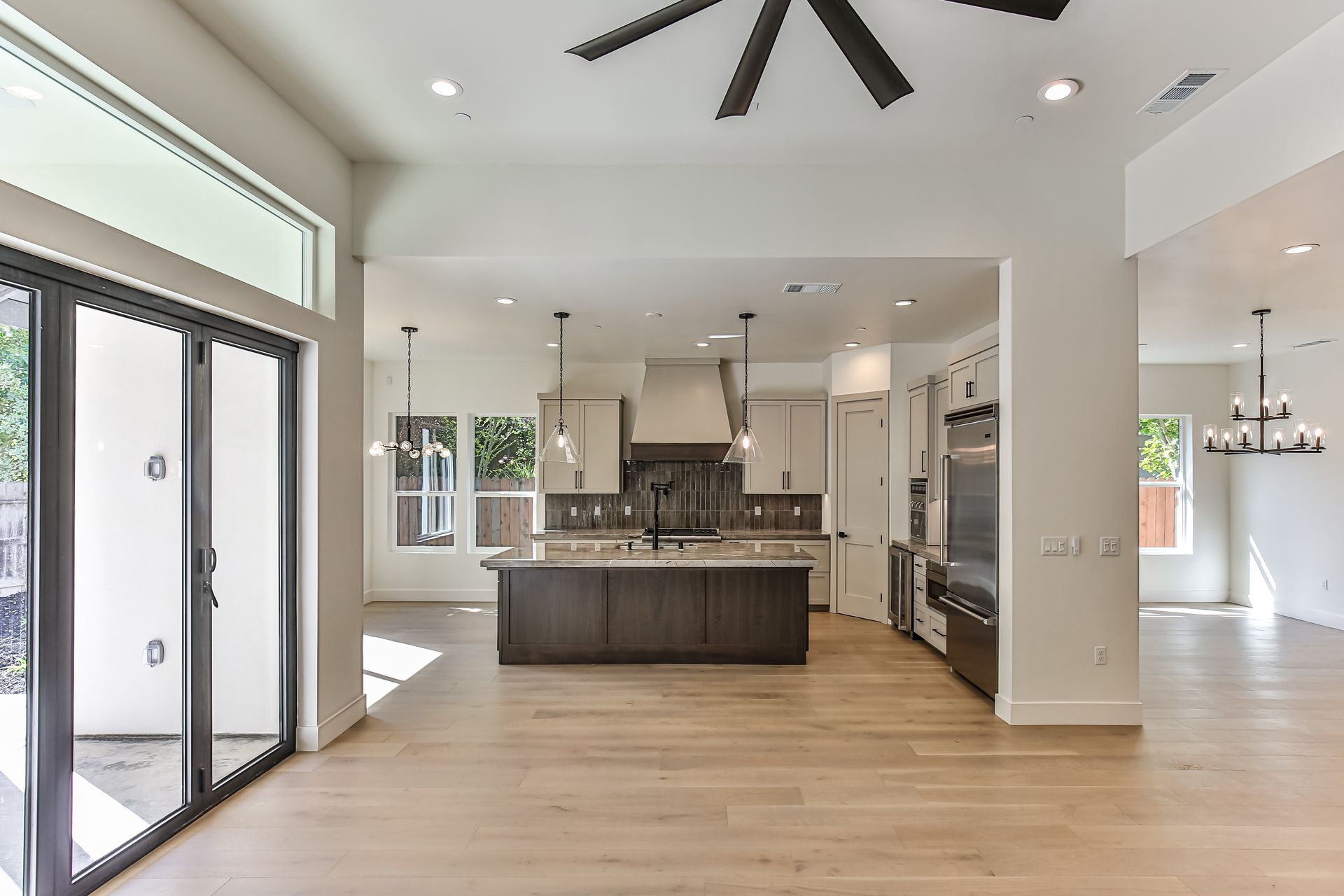 A kitchen with a large island and a ceiling fan.