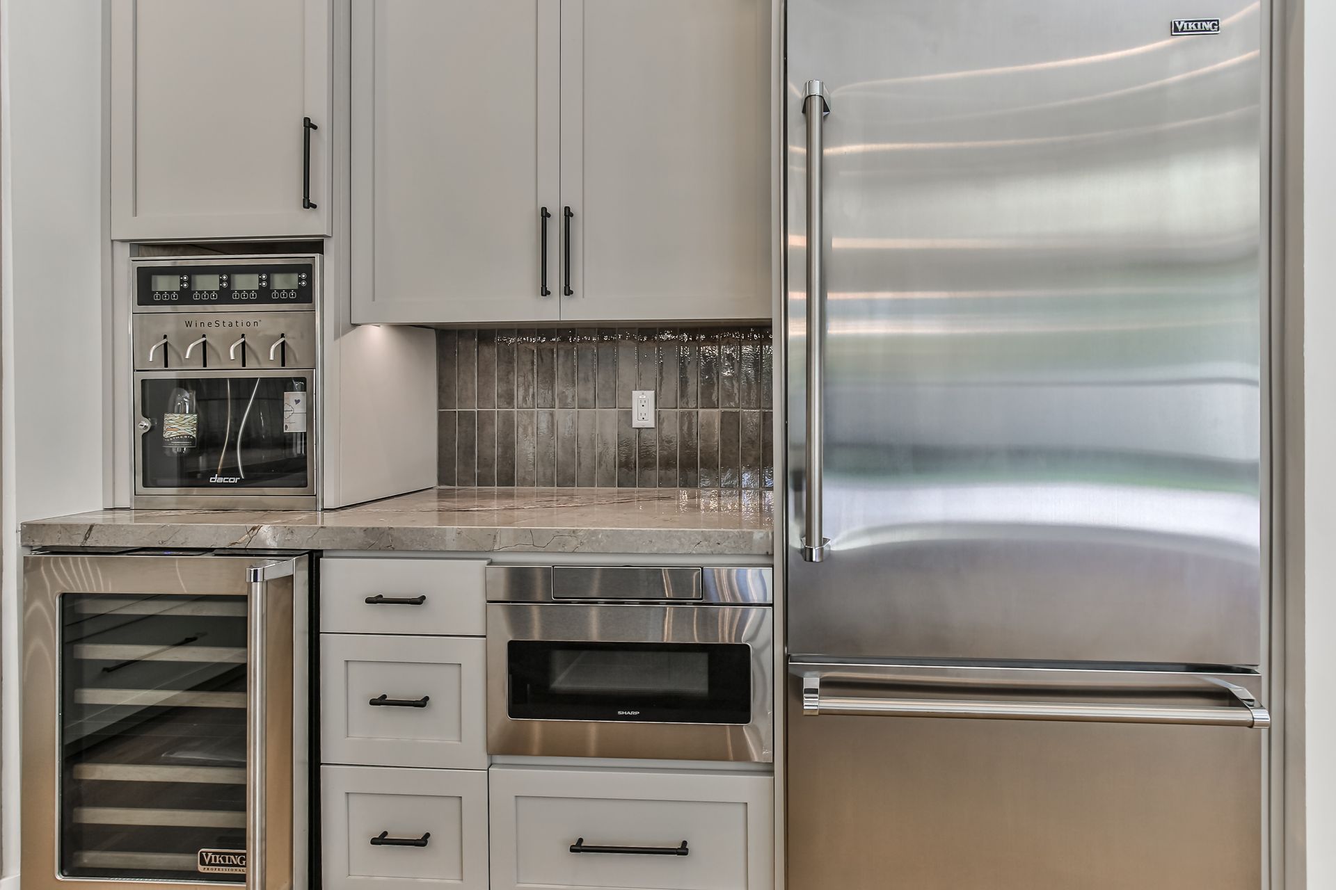 A kitchen with stainless steel appliances and white cabinets.