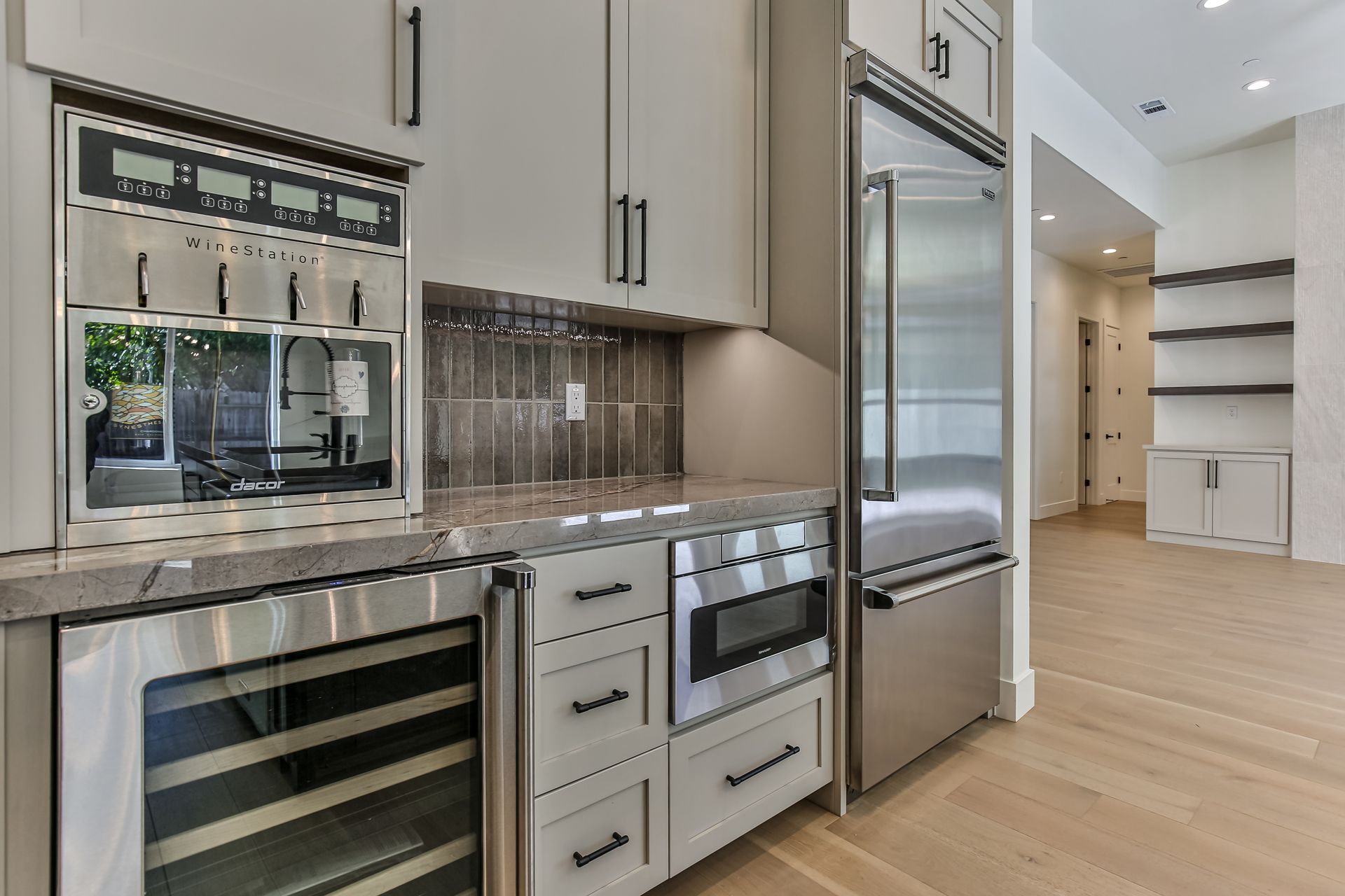 A kitchen with stainless steel appliances and white cabinets.