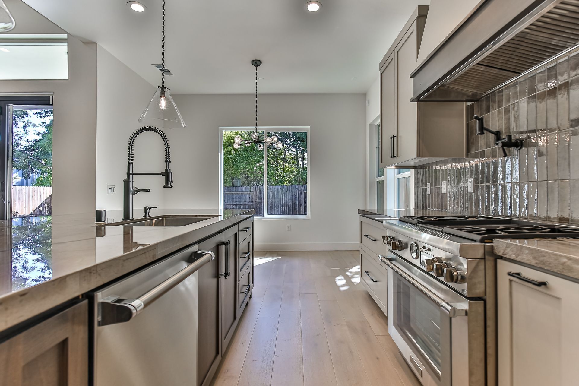 A kitchen with stainless steel appliances and a large window