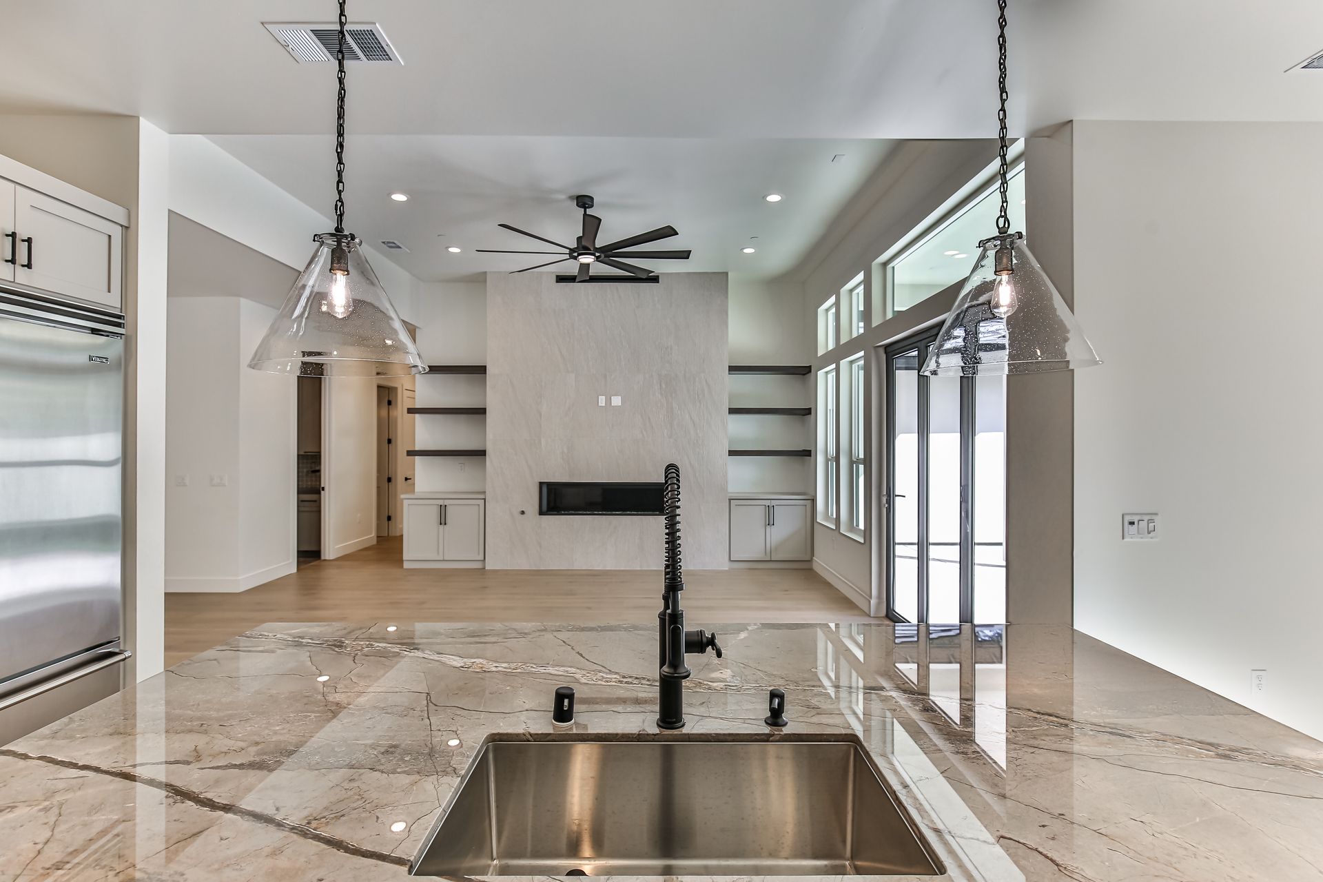 A kitchen with a stainless steel sink and a ceiling fan