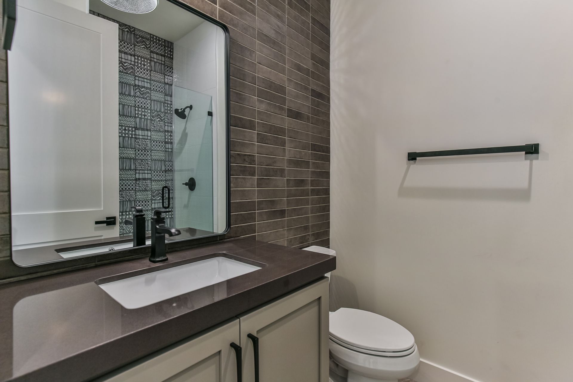 A bathroom with a sink , toilet and mirror.