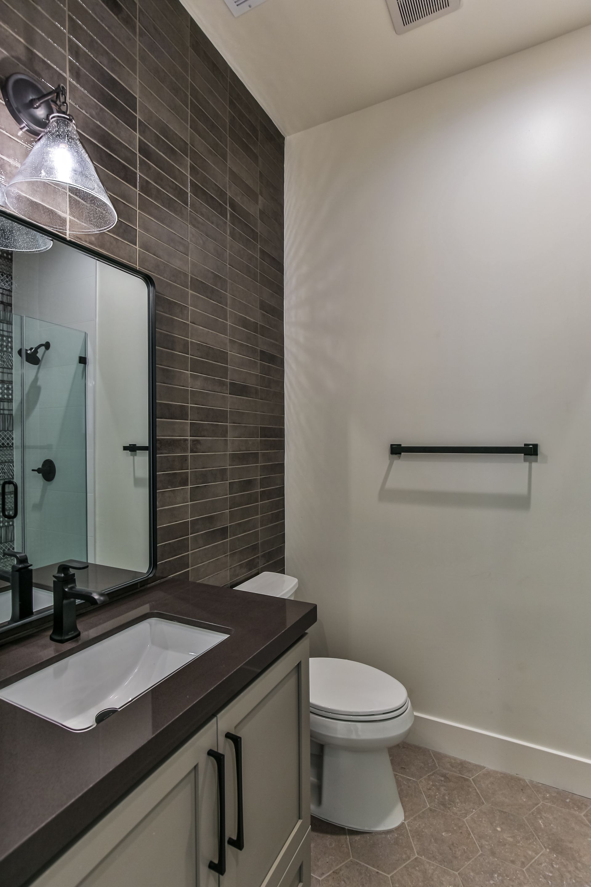 A bathroom with a toilet , sink and mirror