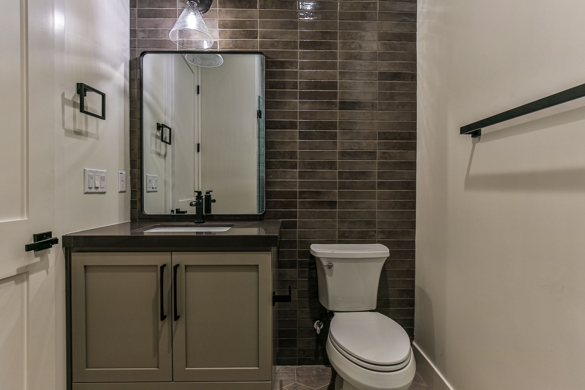 A bathroom with a toilet , sink and mirror.
