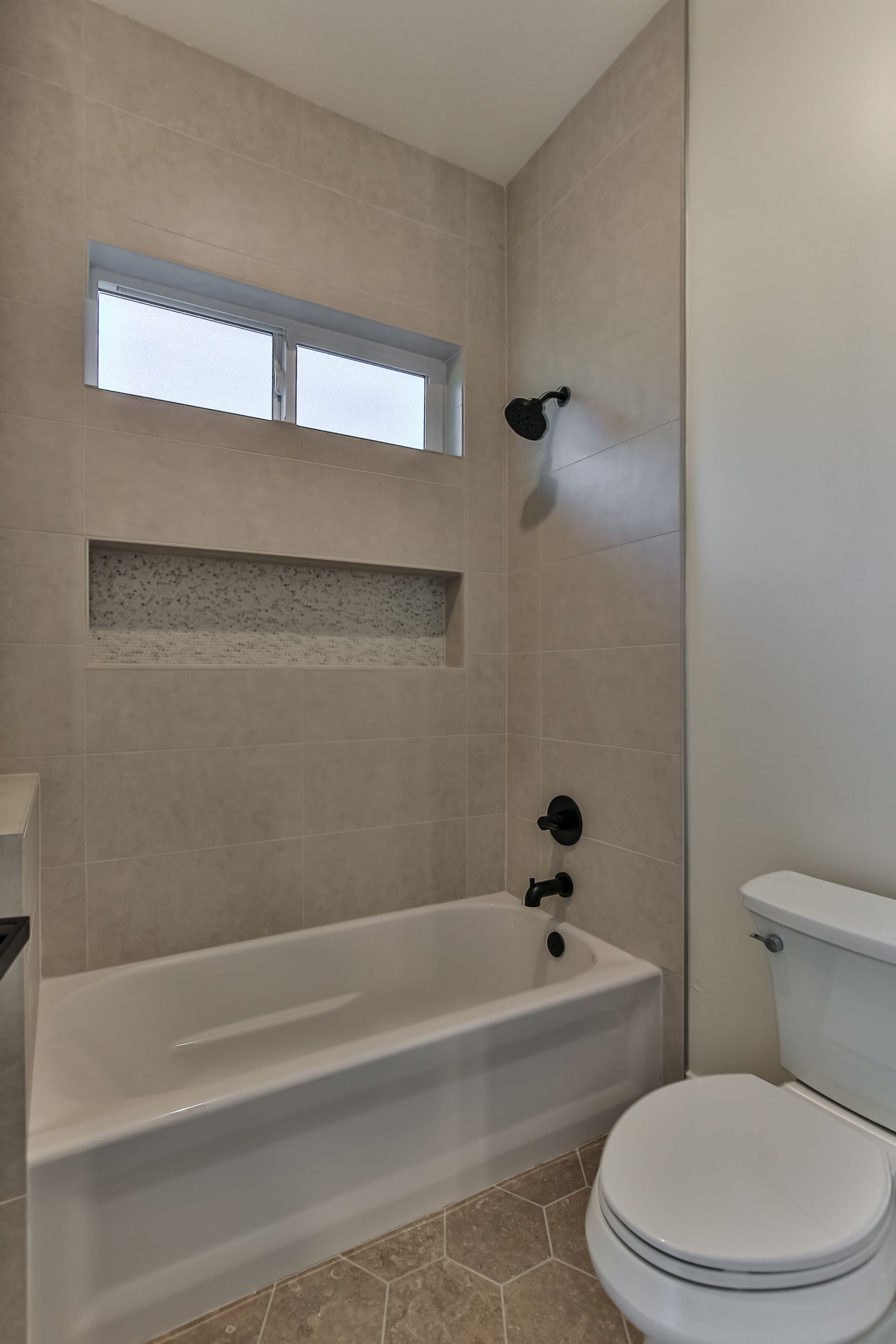 A bathroom with a tub , toilet and shower.