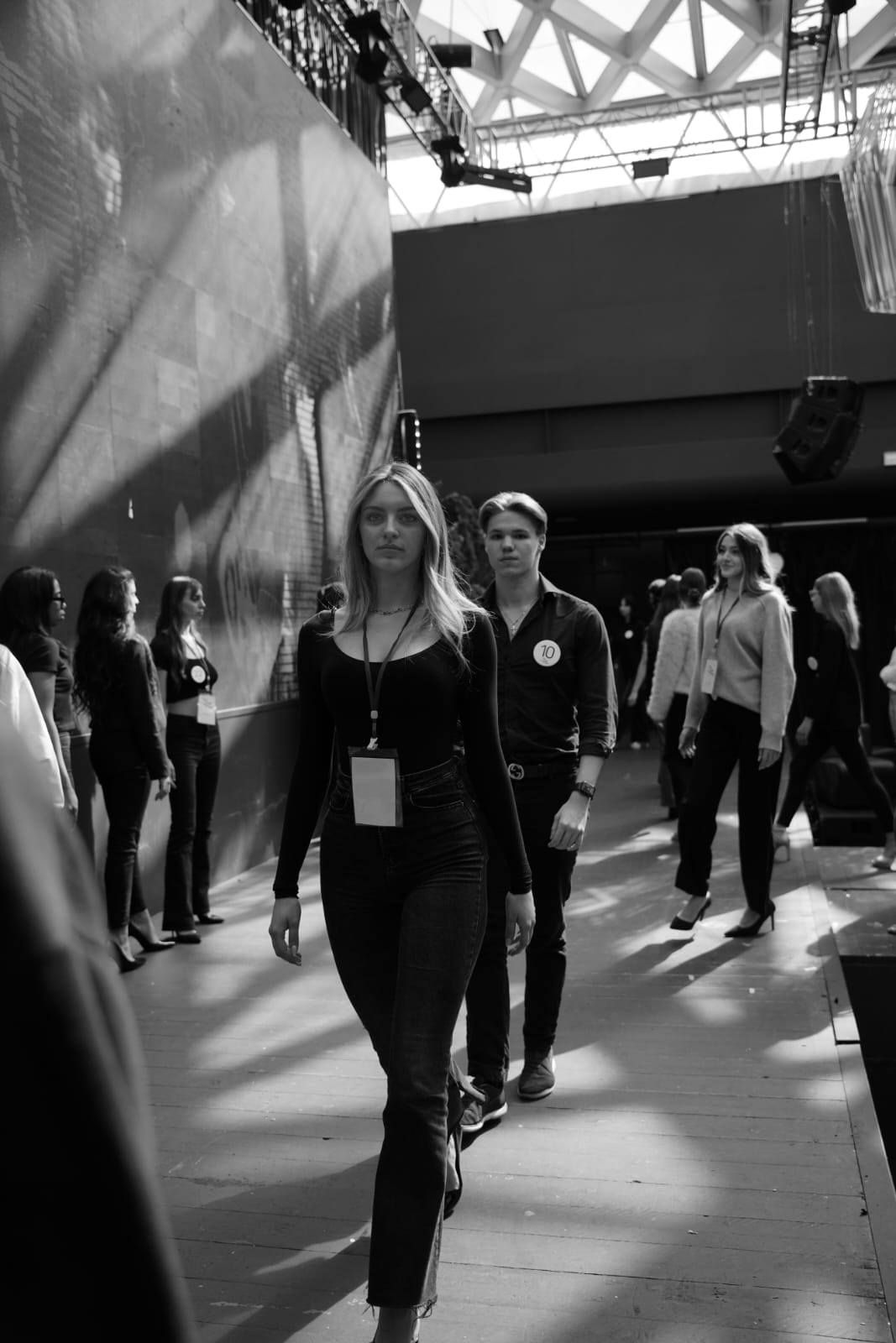 Un gruppo di persone cammina lungo un corridoio in una foto in bianco e nero.