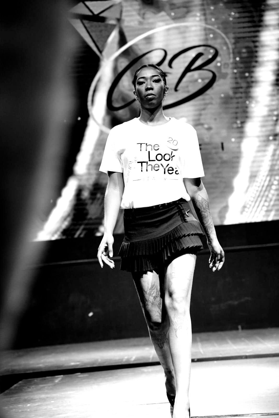 Una foto in bianco e nero di una donna che cammina su una passerella.