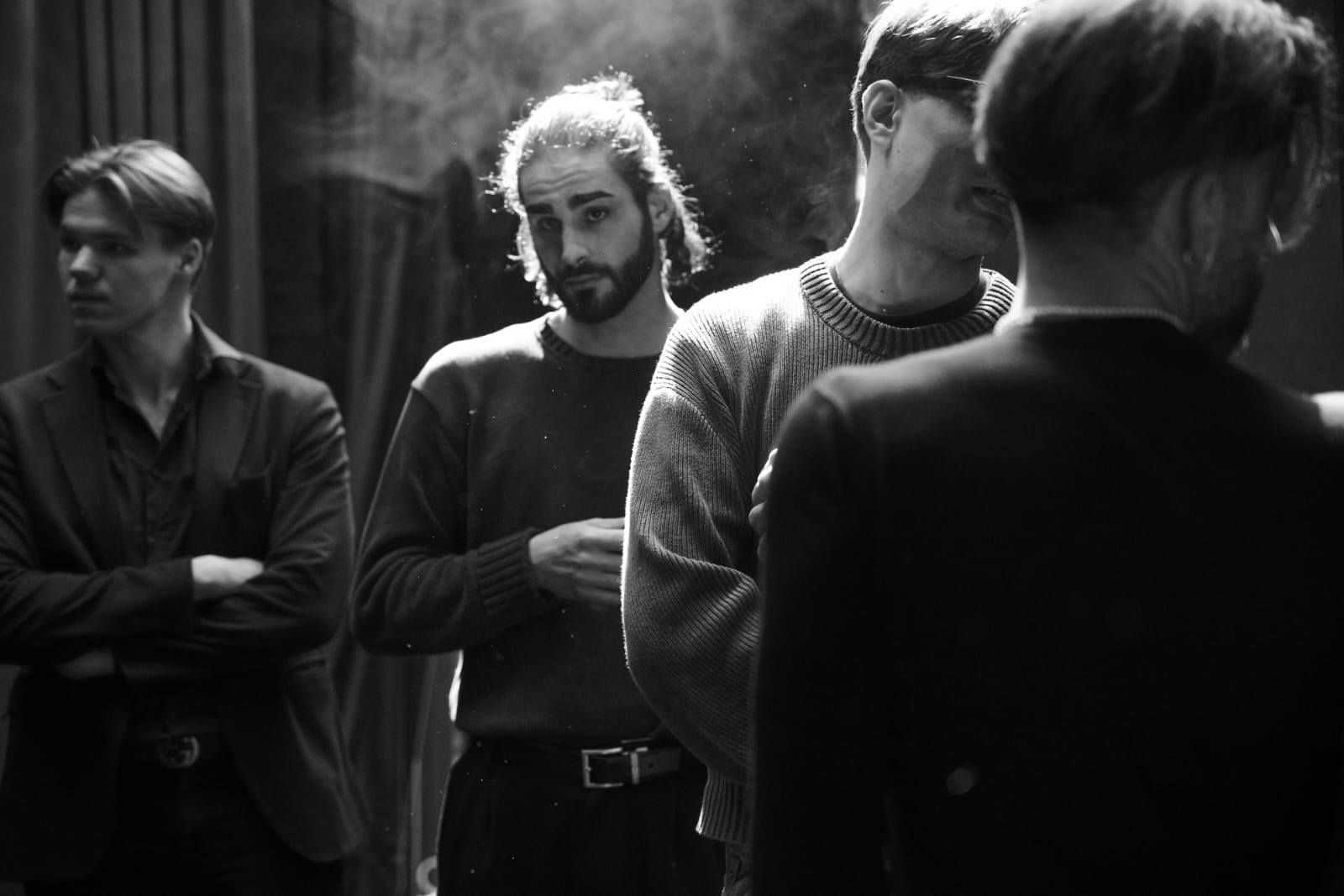 Un gruppo di uomini sono in piedi uno accanto all'altro in una foto in bianco e nero.